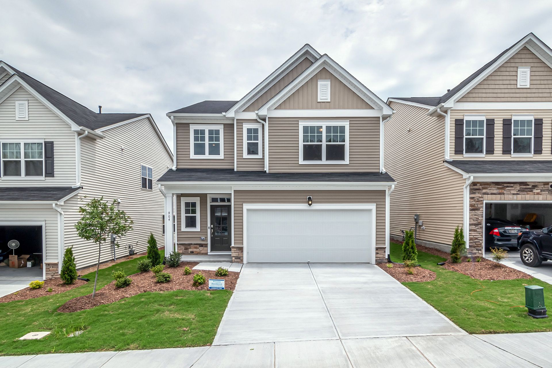 Newly built modern suburban house with a neat front yard and driveway.
