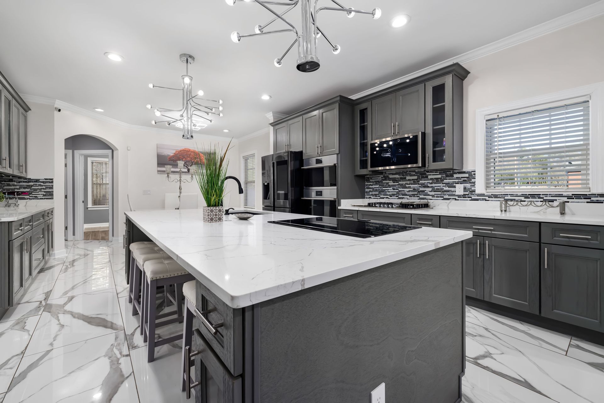 Experience elegance in this luxury modern kitchen featuring marble countertops, sleek cabinetry, and stylish lighting.